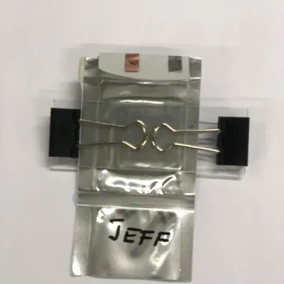 A test pouch cell hand-labeled JEFF, clamped for measurement